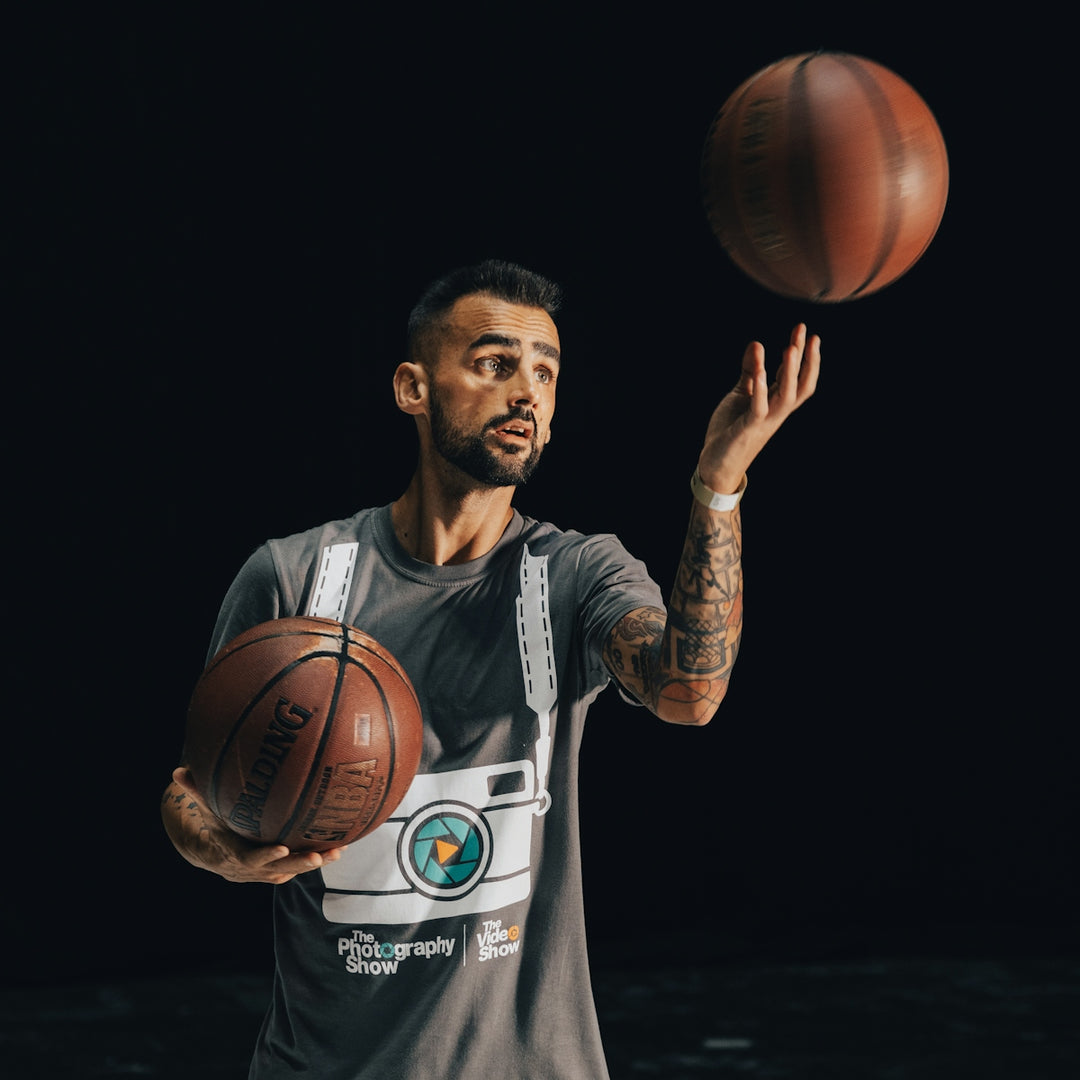 a man holding a basketball in one hand and a basketball in the other