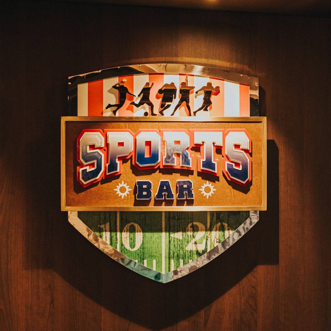 a sports bar sign mounted on a wooden wall