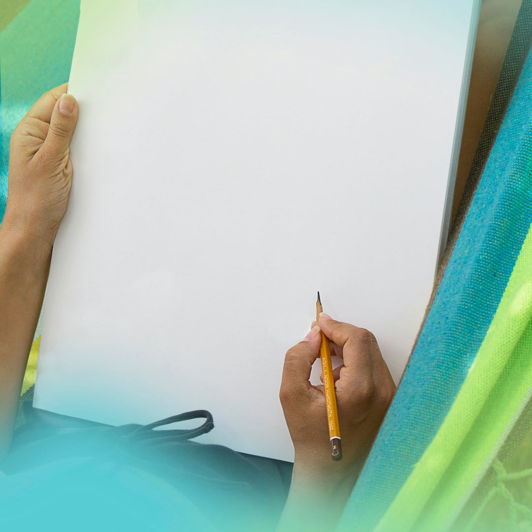a person writing on a piece of paper with a pencil