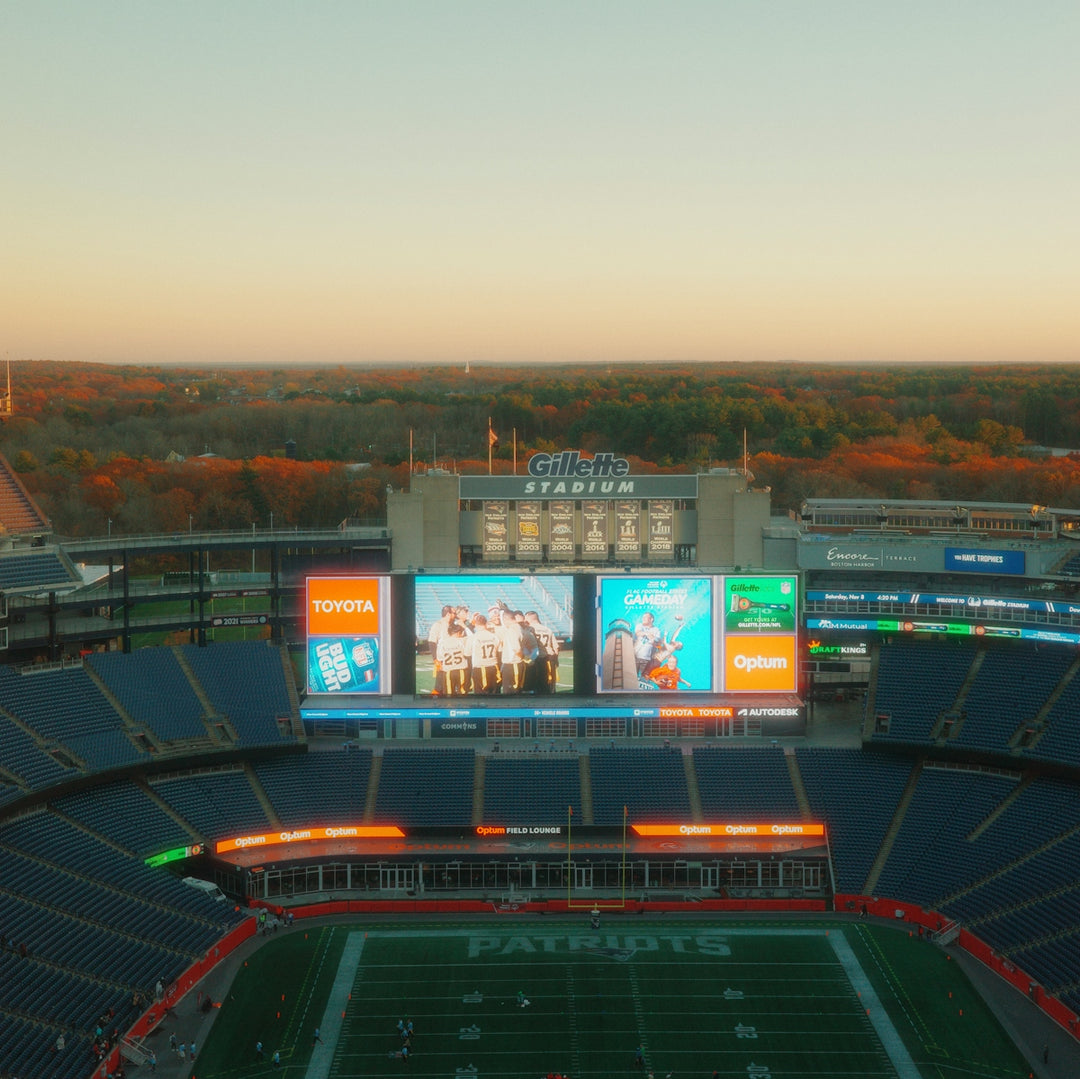 Gillette stadium during a clear sunset with autumn trees.