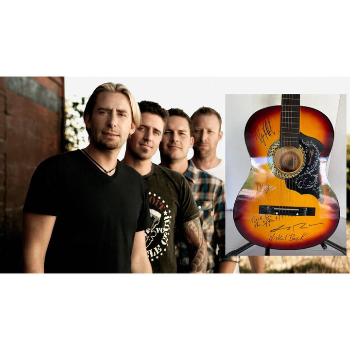 Four men stand outdoors beside a sunburst acoustic guitar with autographs.