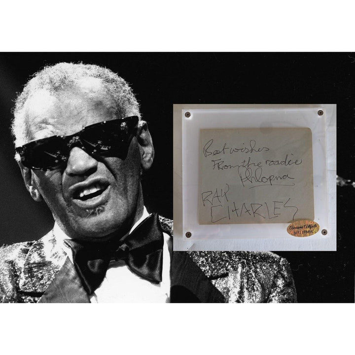 Elderly man in sunglasses and suit; handwritten note on paper beside him.