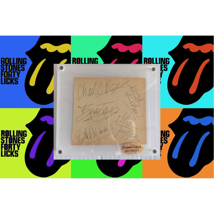 Framed signatures over a colorful pop art background featuring iconic tongue logos.