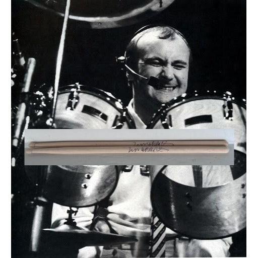 Black and white photo of a smiling drummer with a drumstick in the foreground.