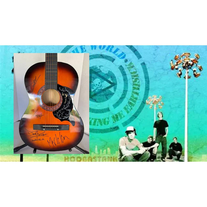 Acoustic guitar with signatures overlaid on a vibrant blue-green background with band members.