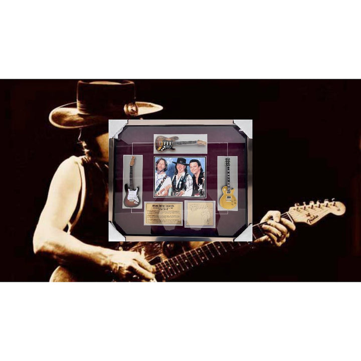 Stevie Ray and Jimmy Vaughan with Eric Clapton signed and framed with proof.