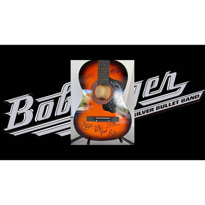 Orange acoustic guitar with signatures, set against a black background with white text.