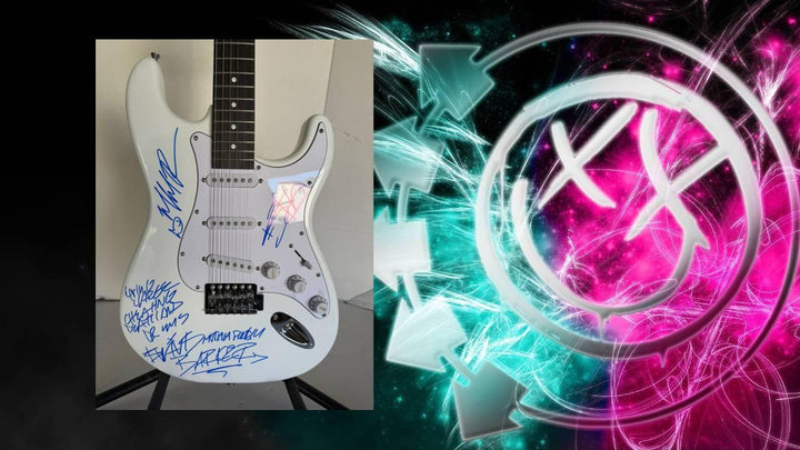 White guitar with blue signatures, set against a vibrant pink and teal abstract background.