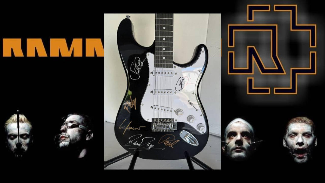 Black guitar with signatures centered on a dark background; orange text and geometric logos flanking.