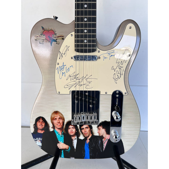 Tom Petty (with sketch) and The Heartbreakers, Ron Blair, Benmont Tench, Scott Thurston, and Mike Campbell full size electric guitar signed.