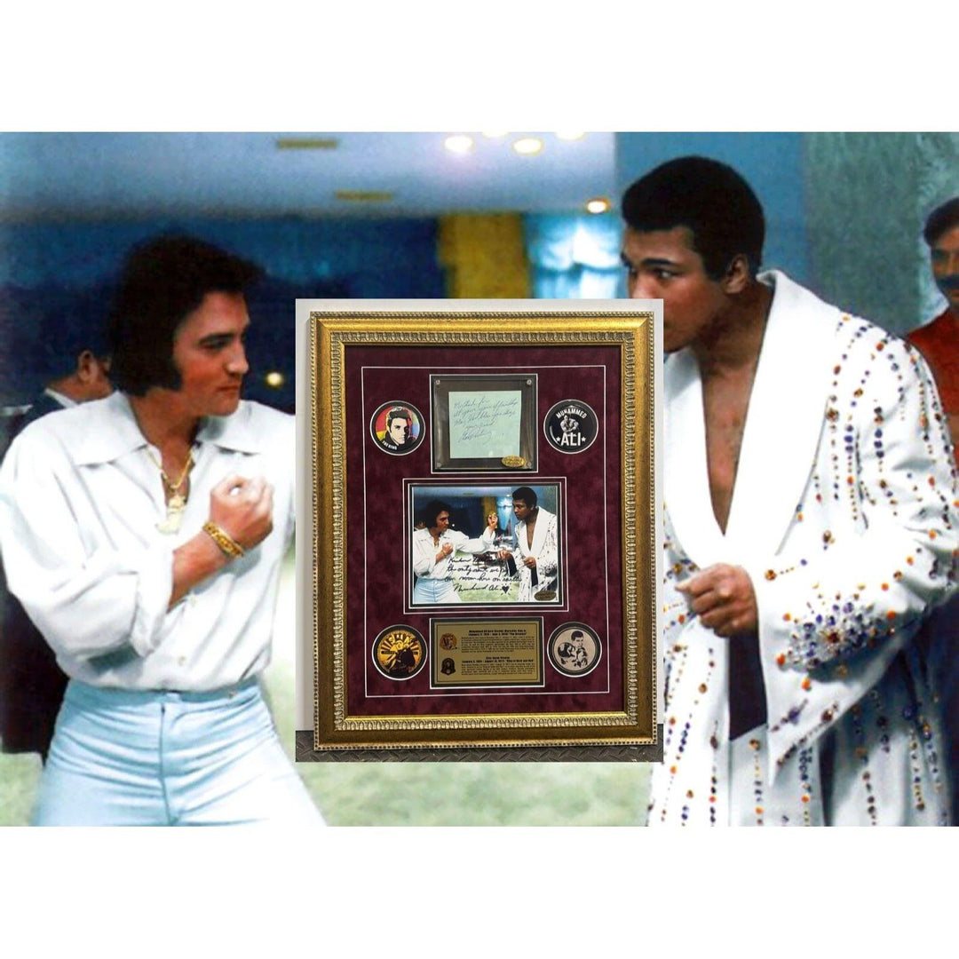 Two men in white outfits admire a framed display in a dimly lit room.