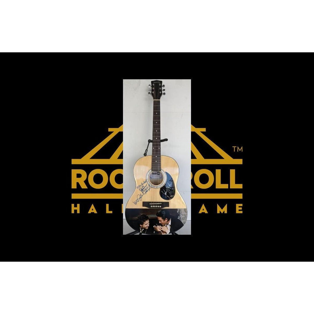 Acoustic guitar on display with "Rock & Roll Hall of Fame" logo in yellow on black background.