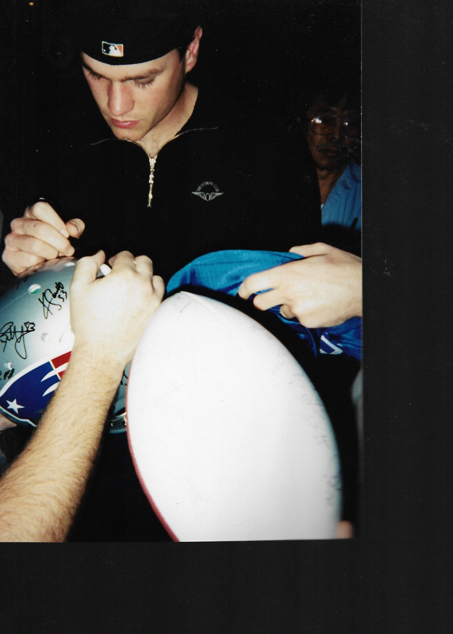 Tom Brady signing a Patriots helmet