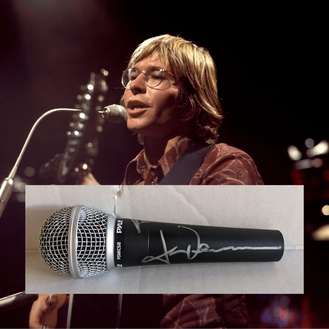 A person singing and playing guitar on stage; superimposed is a black microphone with a signature.