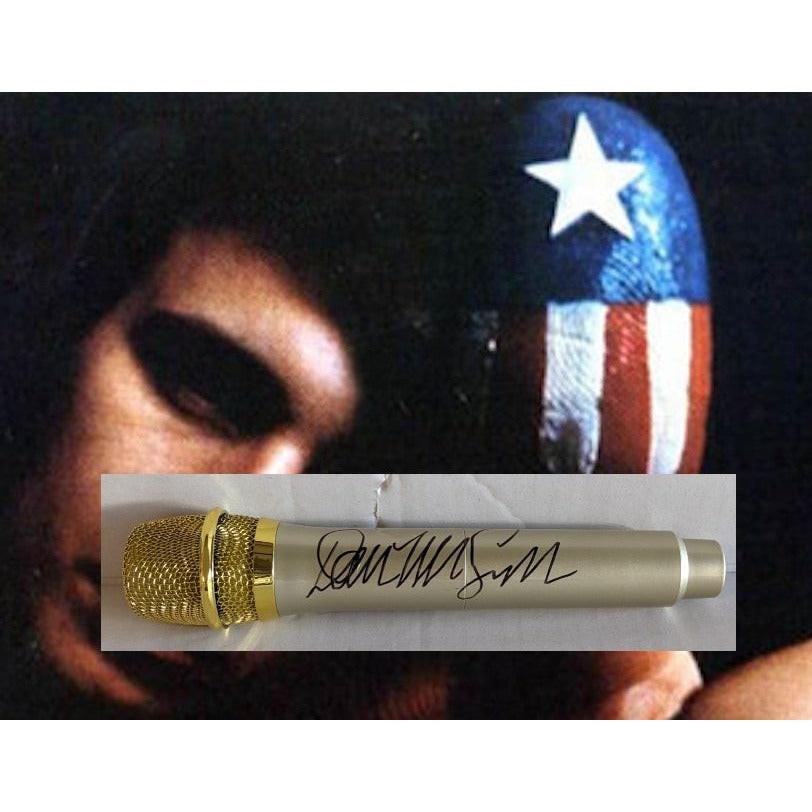 Close-up of a gold microphone with a signature, overlaying a face with a star-spangled helmet.