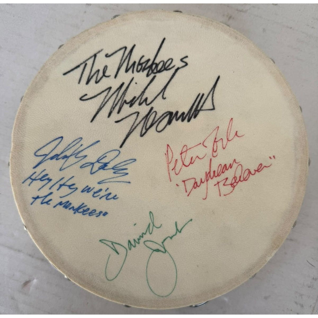 The Monkees signed with inscriptions Michael Nesmith, Davey Jones Mickey Dolenz Peter York Tambourine 8" signed with proof.