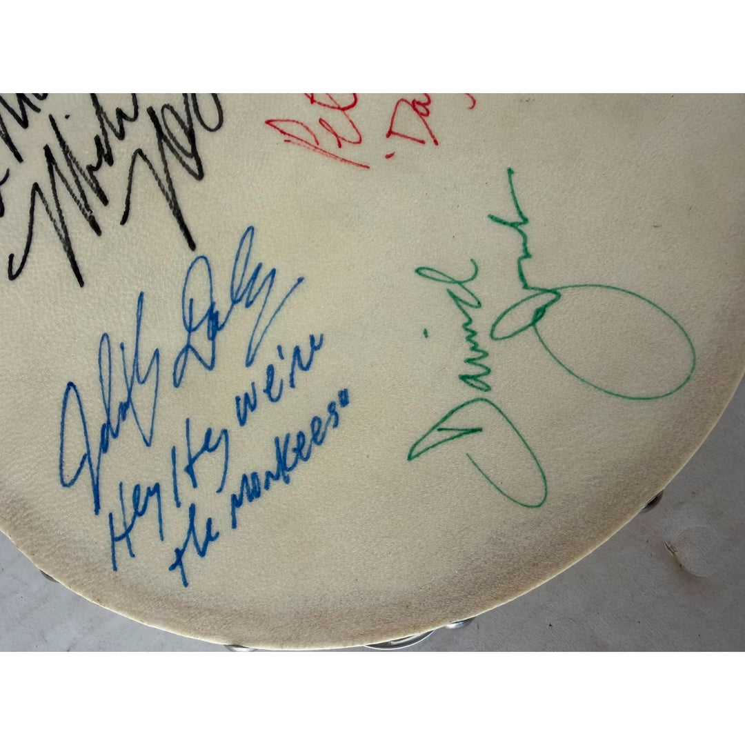 The Monkees signed with inscriptions Michael Nesmith, Davey Jones Mickey Dolenz Peter York Tambourine 8" signed with proof.