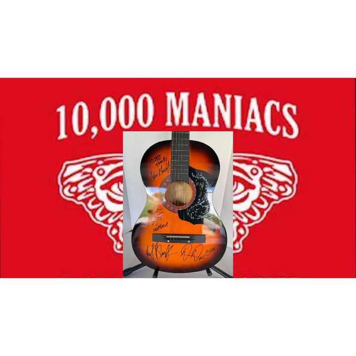 Acoustic guitar with signatures, set against a red background with "10,000 Maniacs" in white.