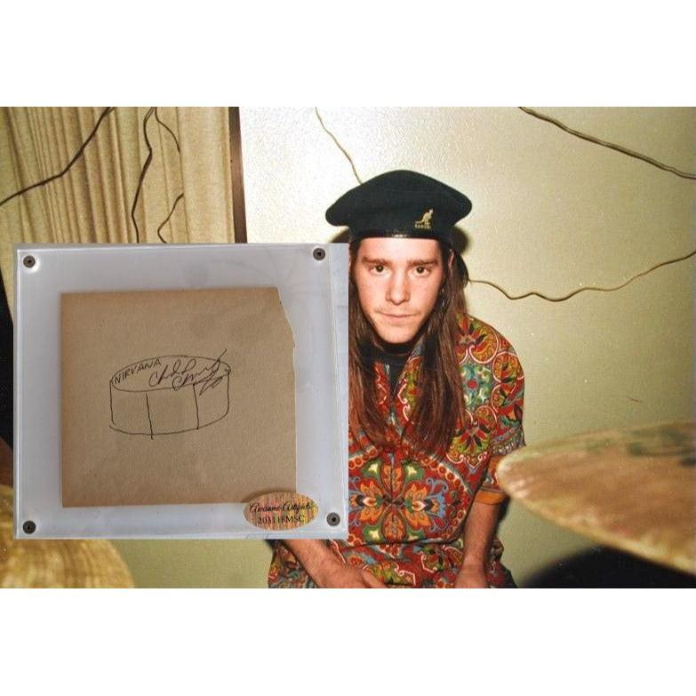 Man in colorful shirt and hat beside drums, with sketch on paper overlayed in the foreground.